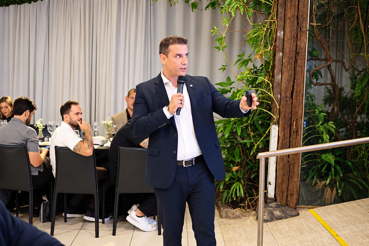 Brenno Porto falando ao microfone durante evento da Growth Leilões